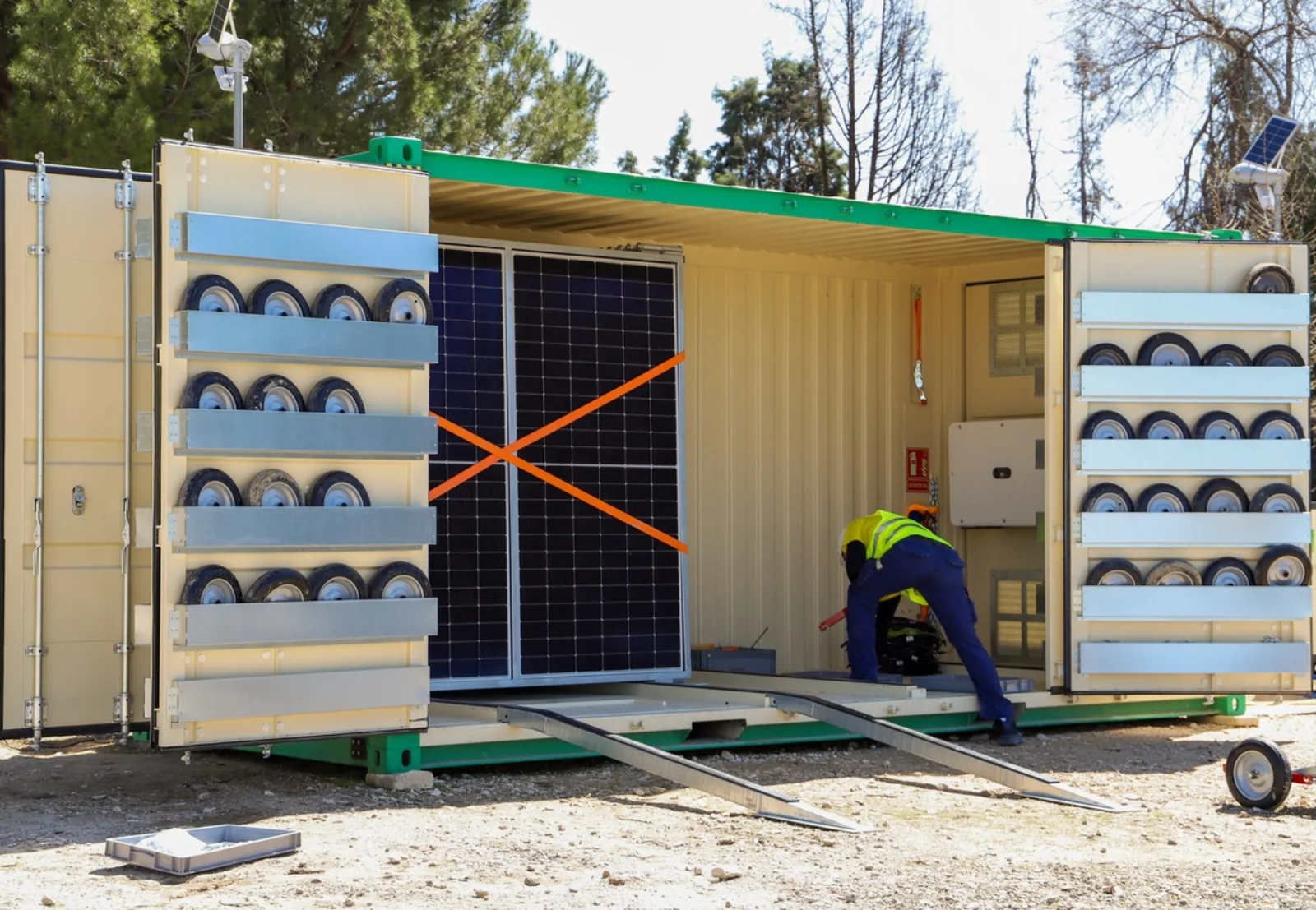 A worker deploying panels from a Nomad solar container